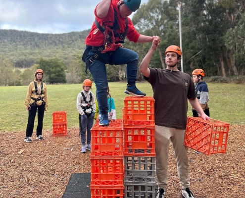 volunteer helping participant climb tower